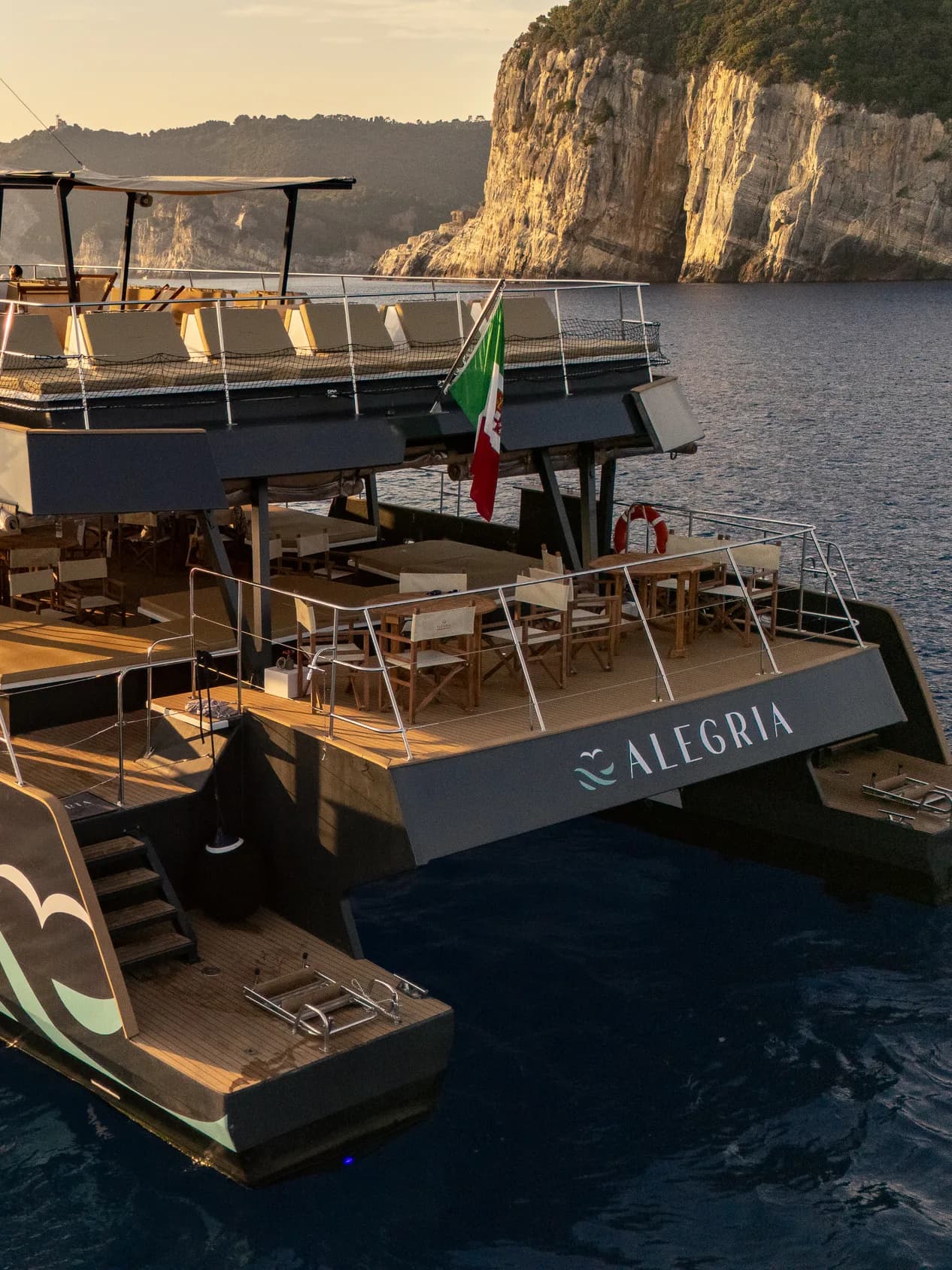 Il catamarano Alegria al tramonto davanti alla costa del golfo, ripreso dal drone