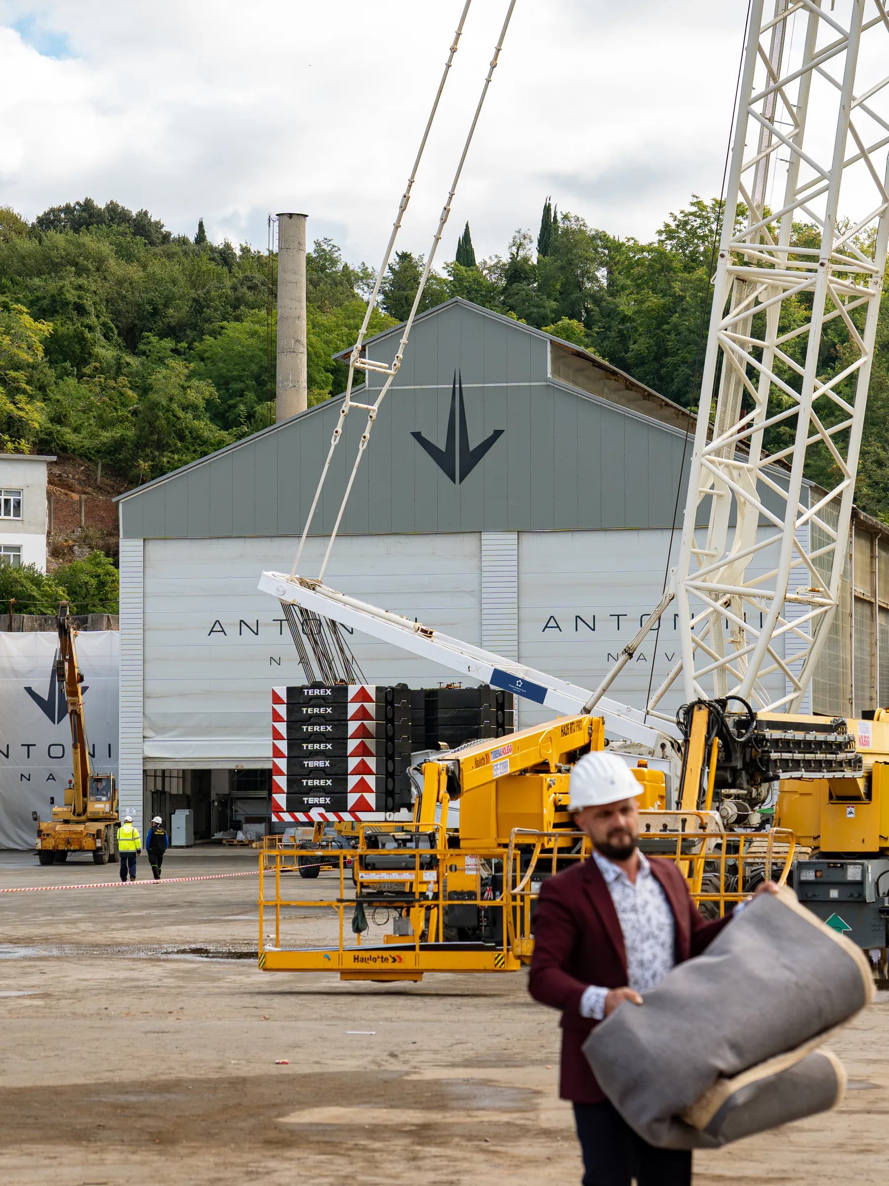 Piazzale del cantiere Antonini Navi con il capannone, le gru e i mezzi di sollevamento