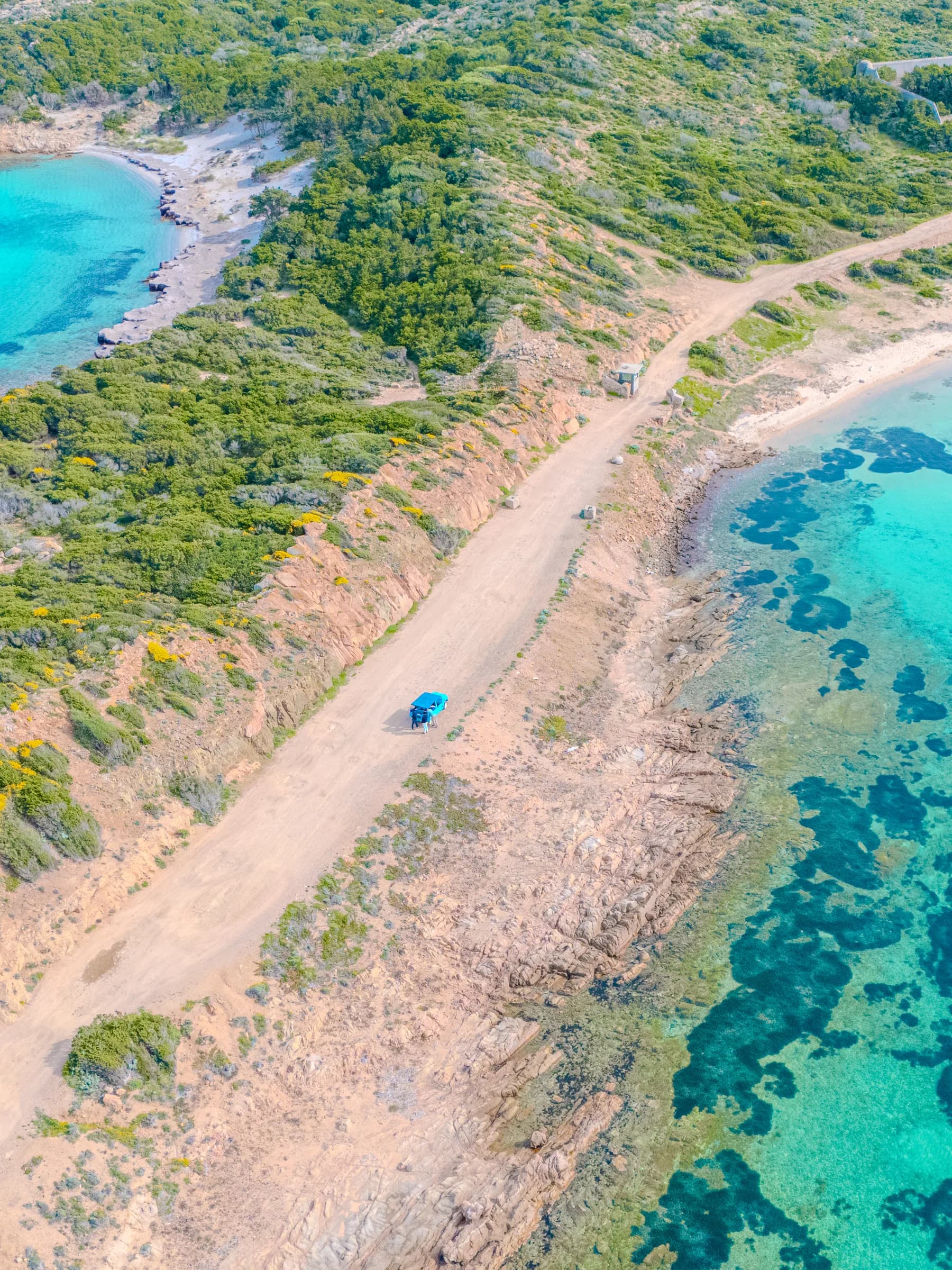Costa della Maddalena vista dal drone, con la strada sterrata, la spiaggia e i fondali turchesi