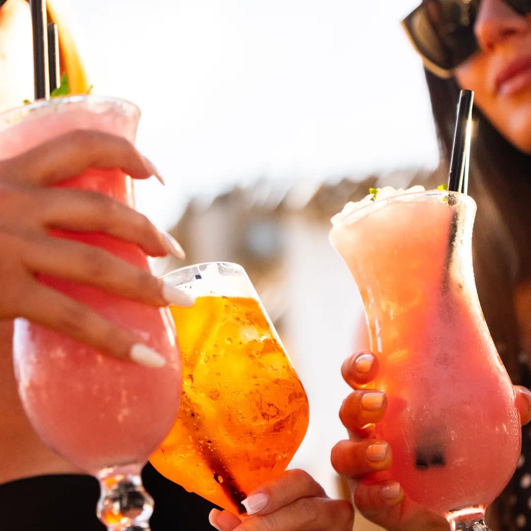 Due cocktail alzati davanti alla spiaggia in controluce