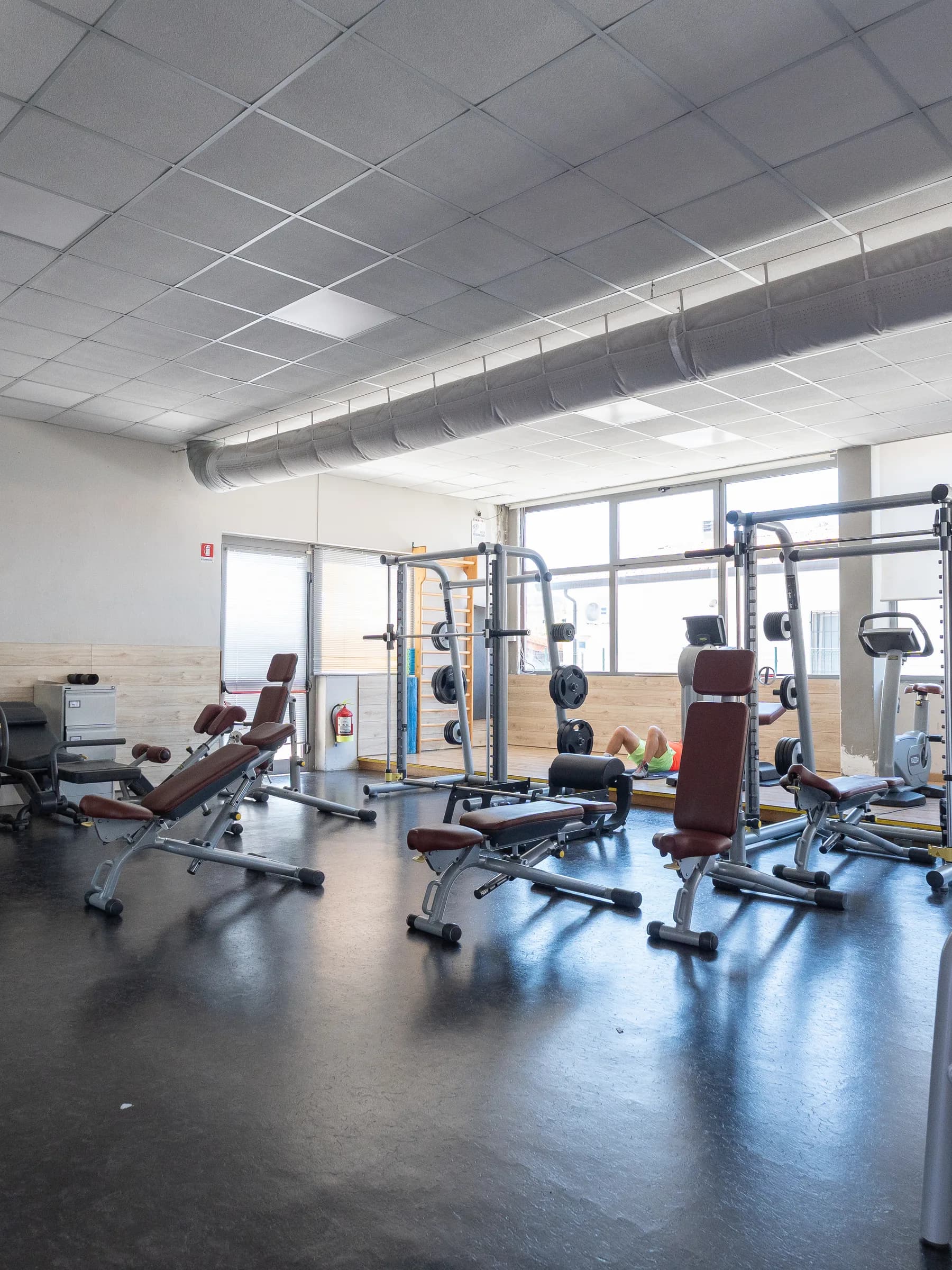 Sala attrezzi della palestra Kleb con le macchine allineate e le vetrate sul fondo
