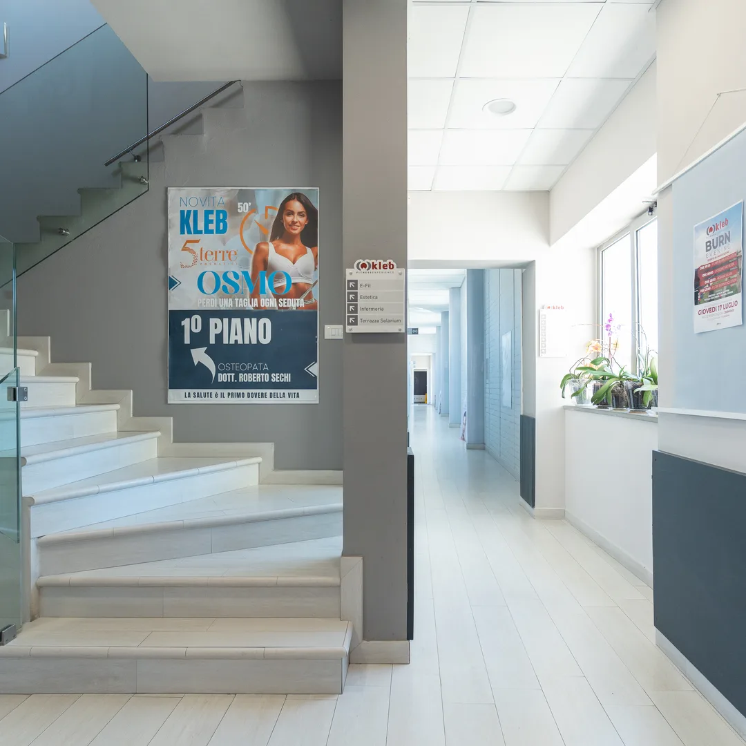 Il corridoio d'ingresso della palestra con le scale e le insegne dei piani
