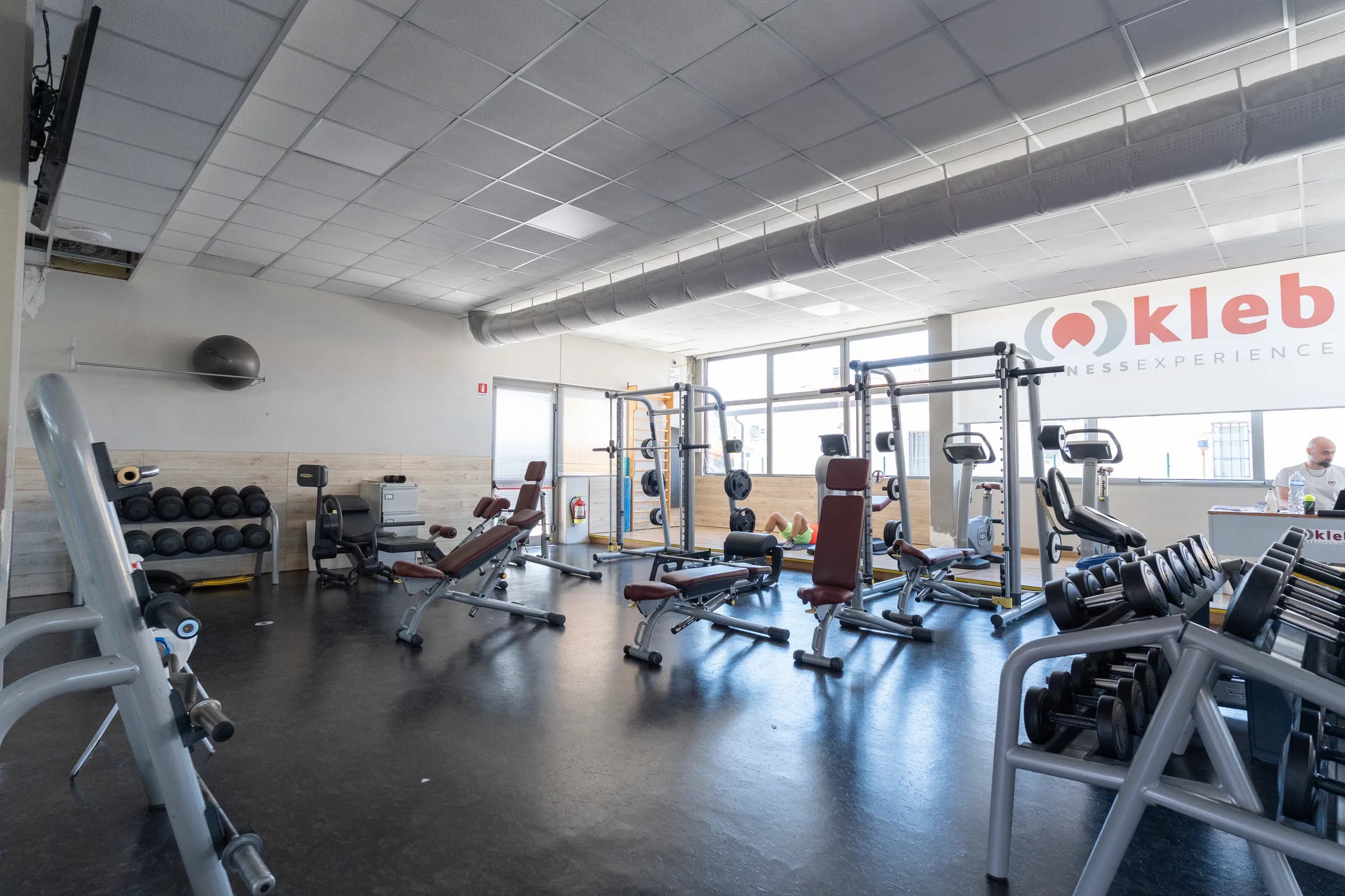 Sala attrezzi della palestra Kleb con le macchine allineate e le vetrate sul fondo