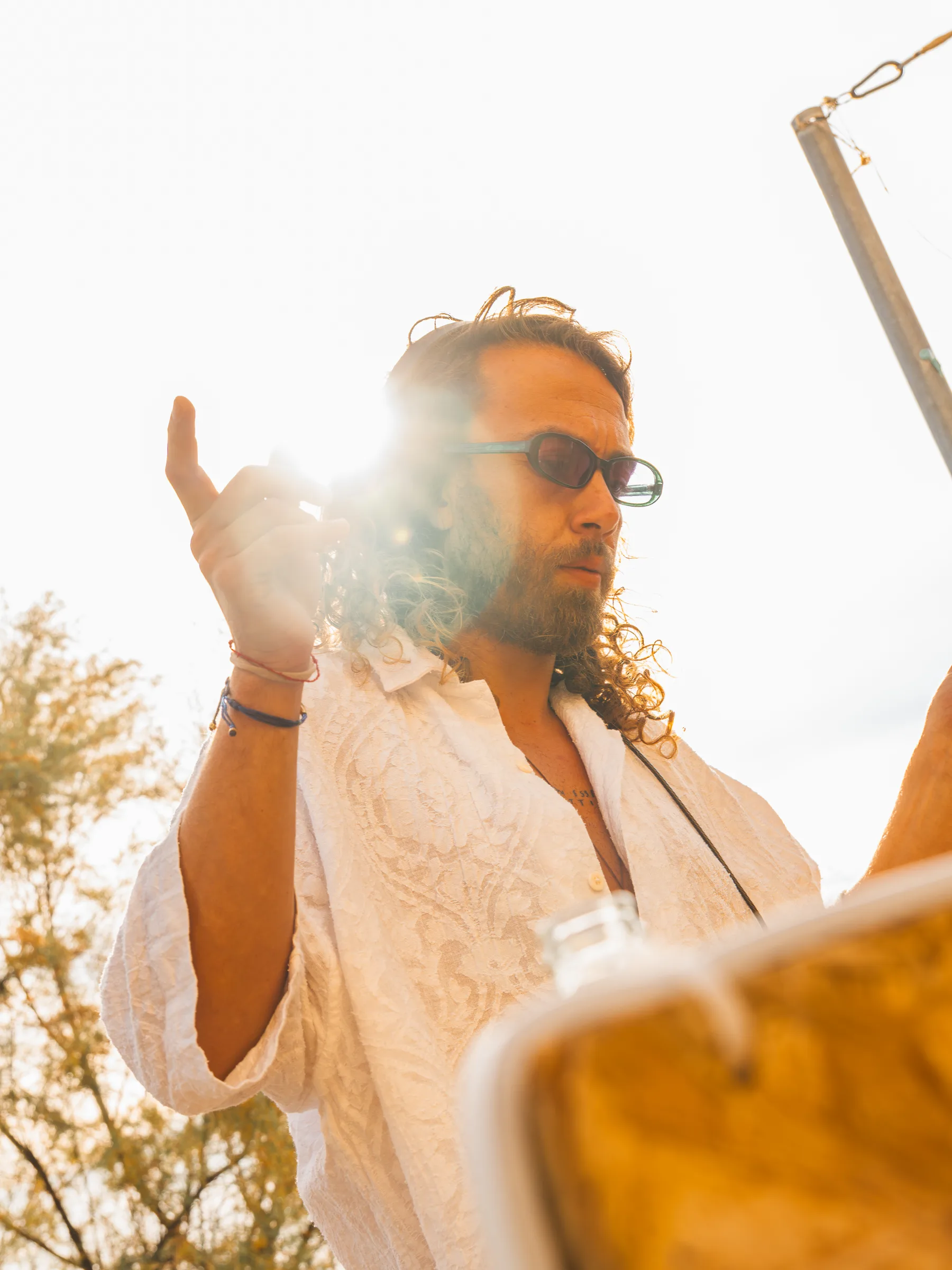 Ritratto in controluce di un dj di Lazy Buns con il sole fra le dita