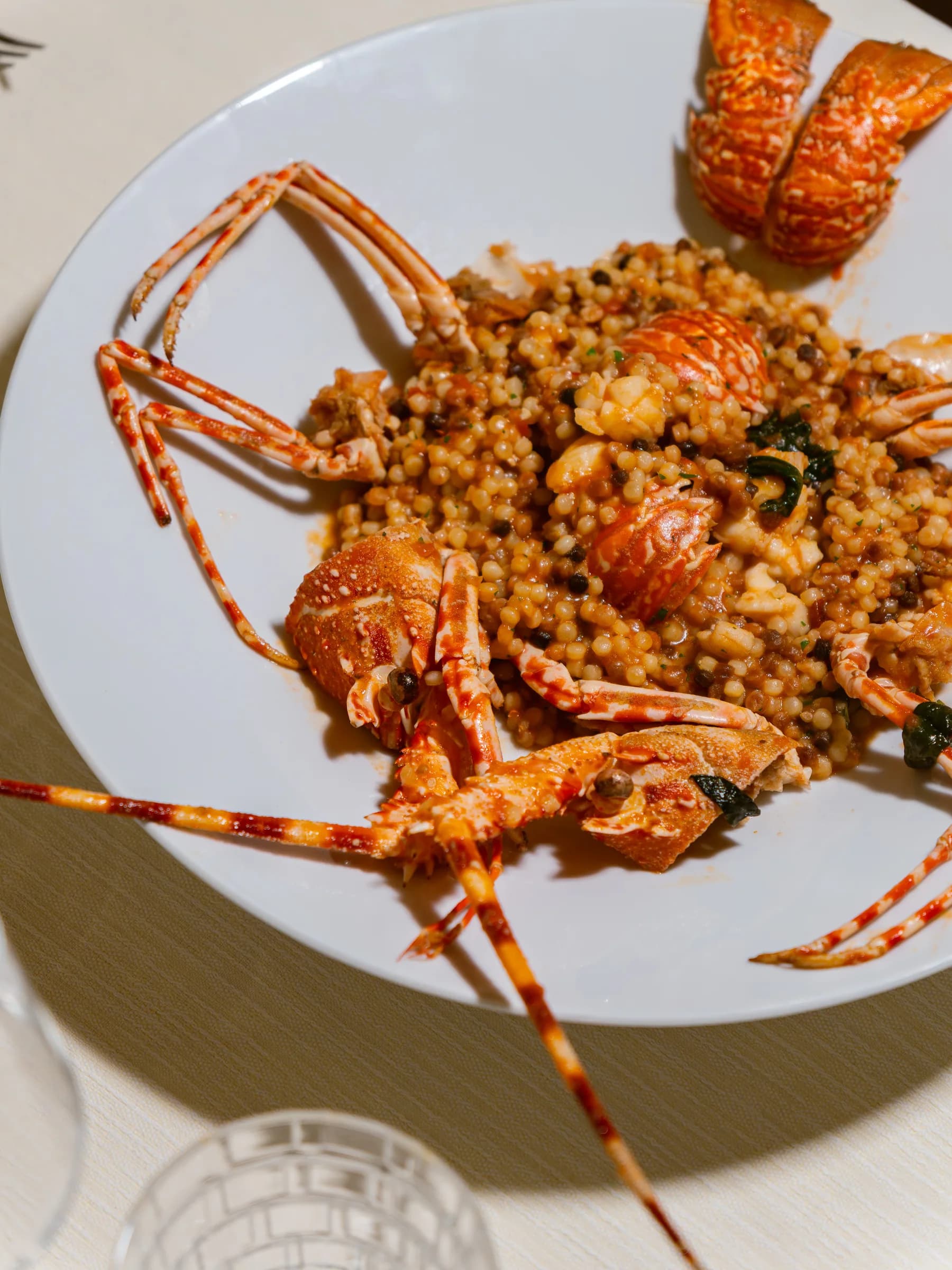 Fregola con crostacei servita nel piatto, piatto di mare di Ottone