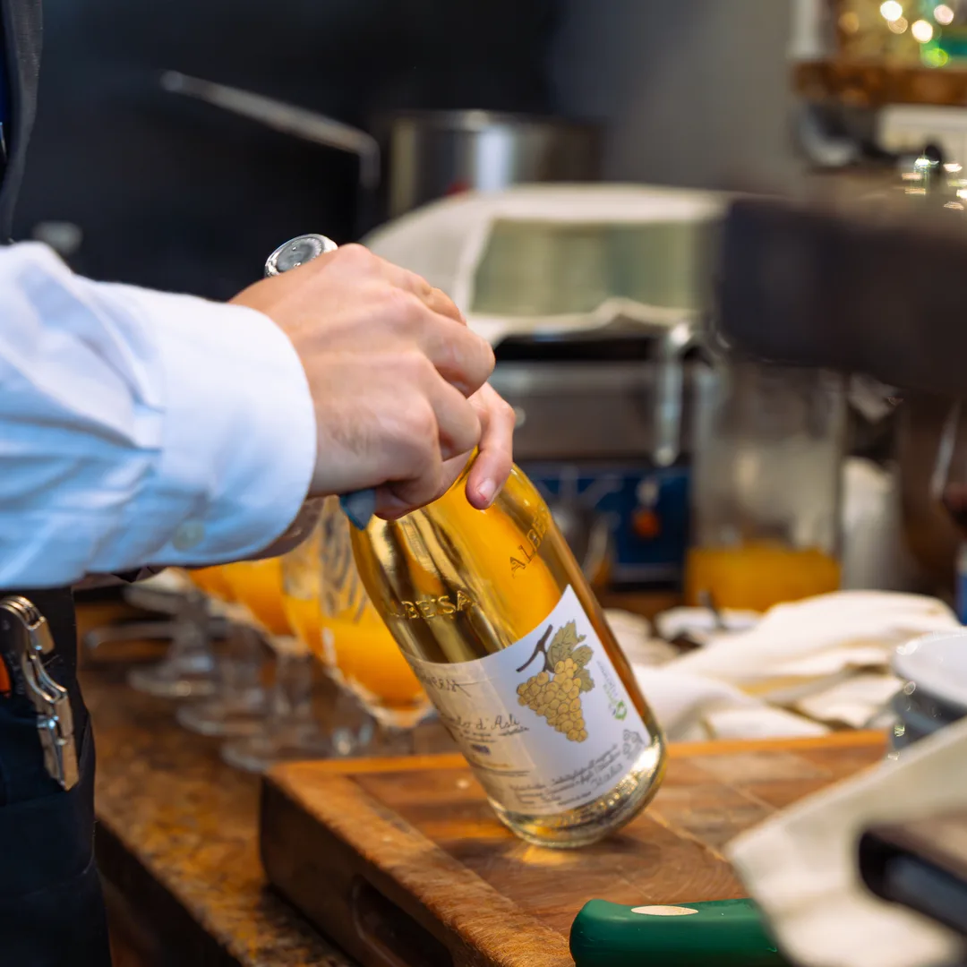 Il sommelier versa il vino bianco al banco di Ottone