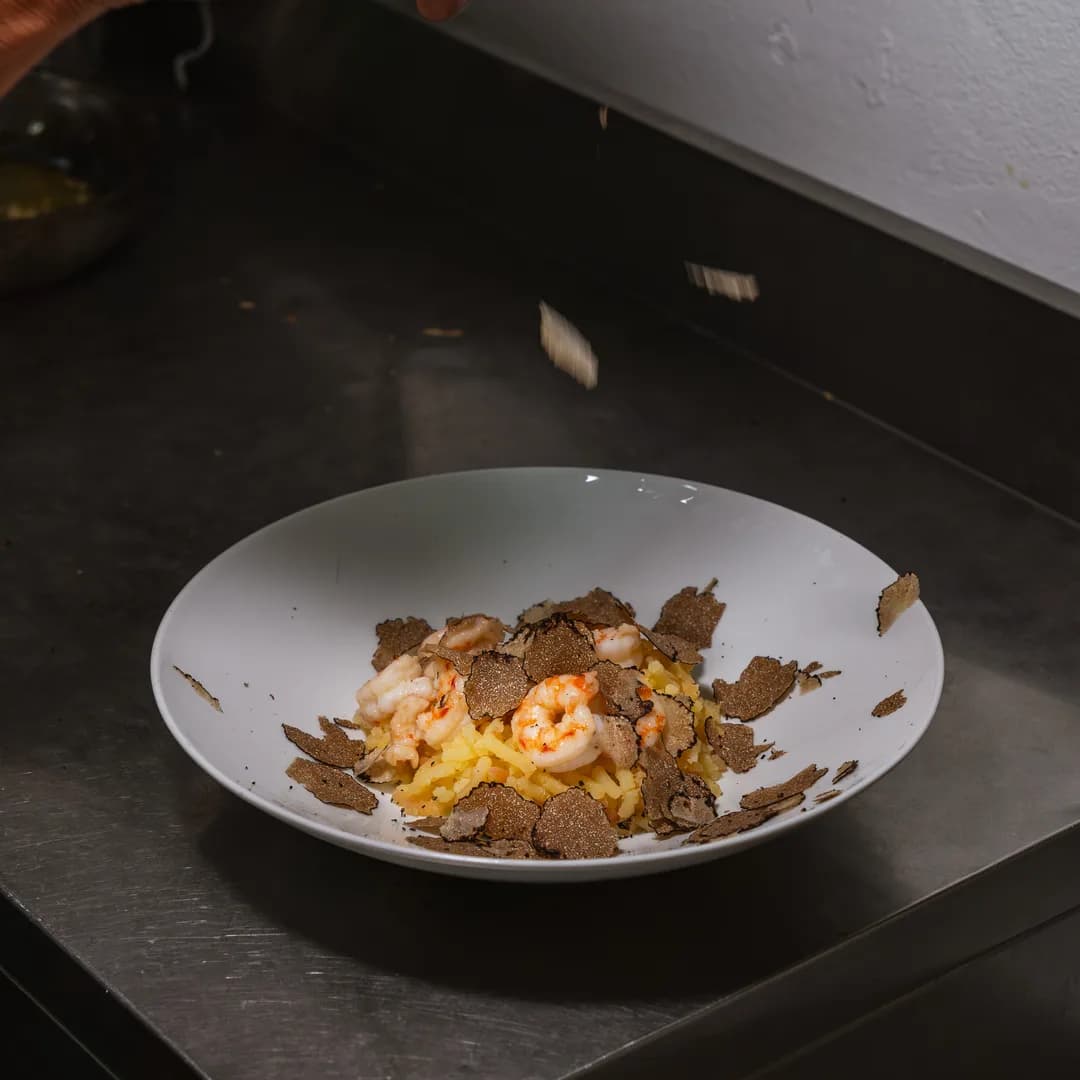 Piatto con le scaglie di tartufo nero sul bancone scuro della cucina