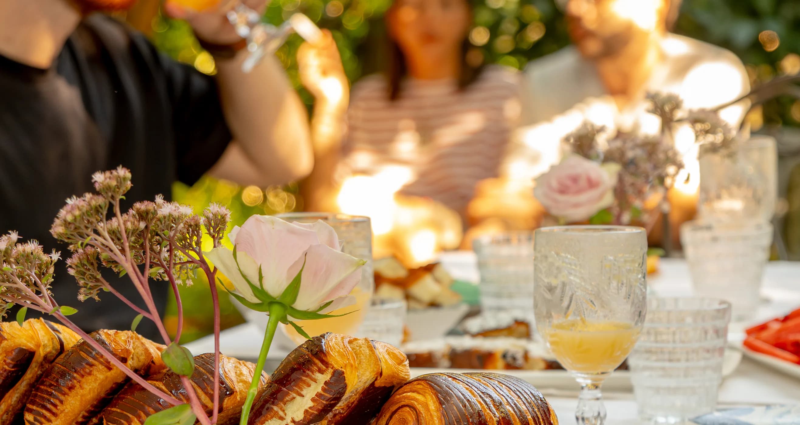 Il tavolo del brunch di Ottone apparecchiato all'aperto, con i lievitati e i calici nella luce del pomeriggio