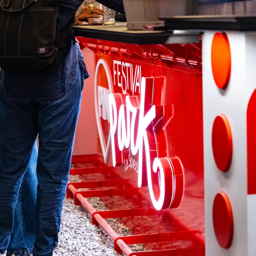 Il chiosco rosso del festival con l'insegna al neon PiN park