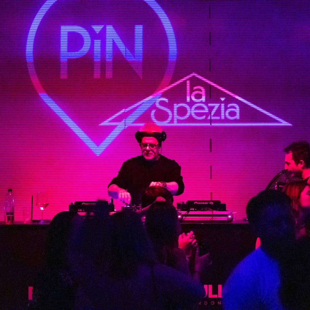 Dj set serale davanti alla scritta al neon del locale