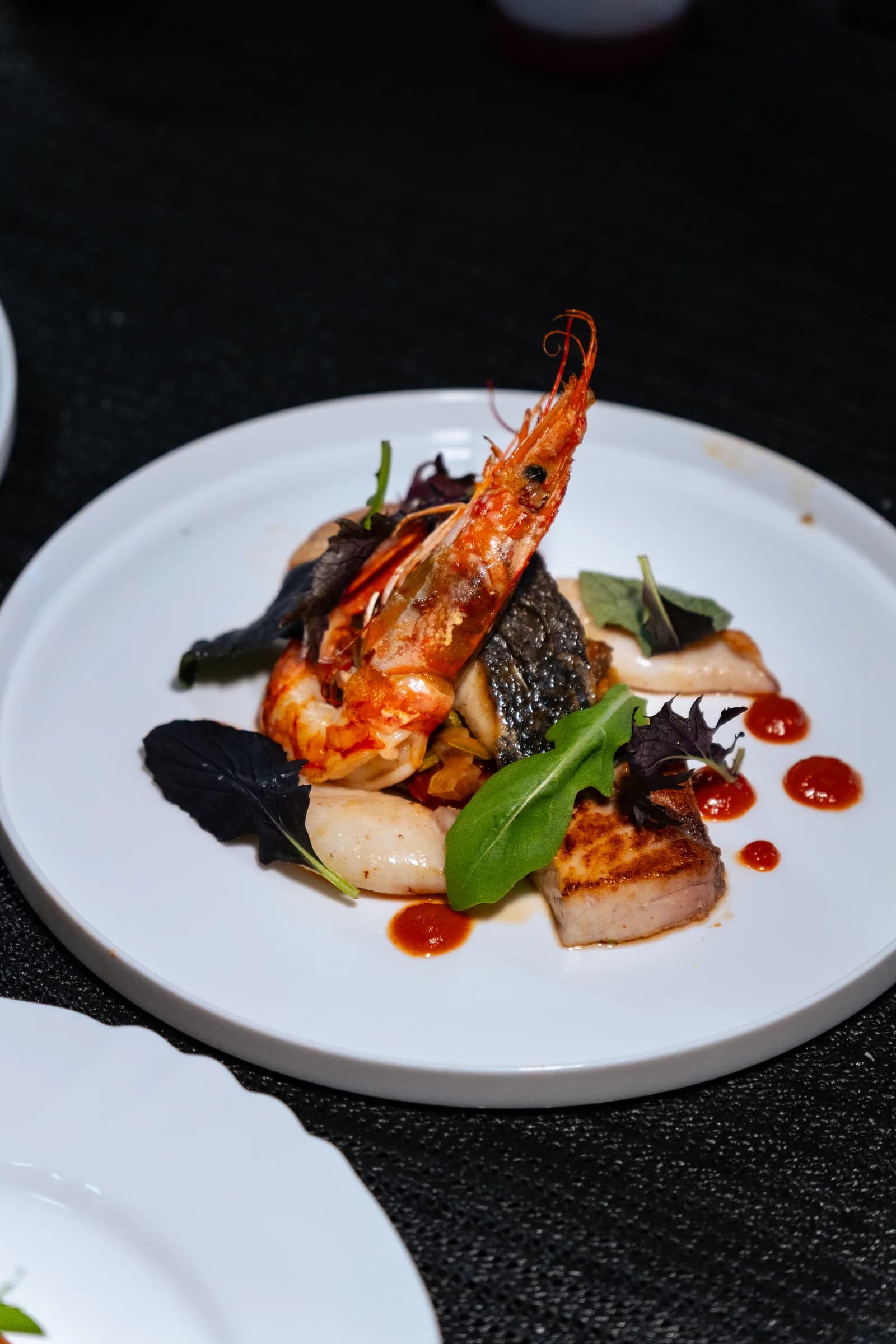 Piatto con gambero, filetto di pesce e calamari serviti al PiN la Spezia