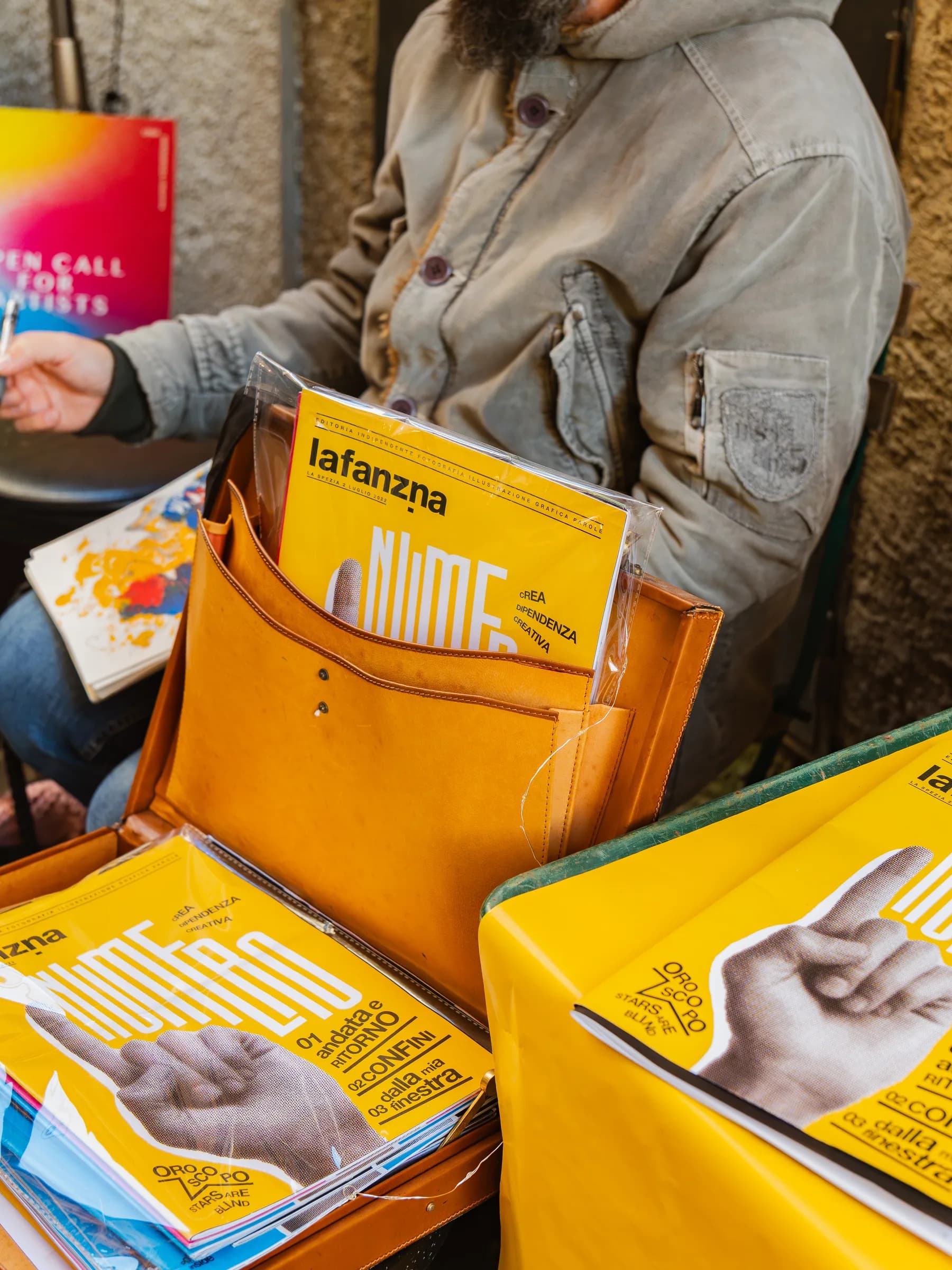 Fanzine e riviste indipendenti esposte su un banco giallo al festival Propaganda