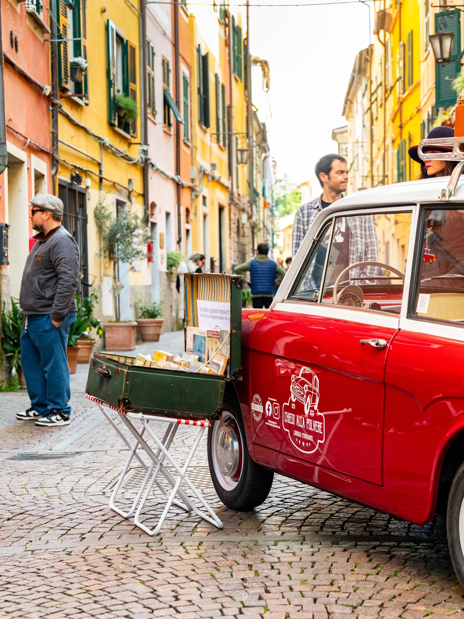 Libreria itinerante ricavata da una Fiat 500 rossa, parcheggiata in un vicolo durante il festival Propaganda