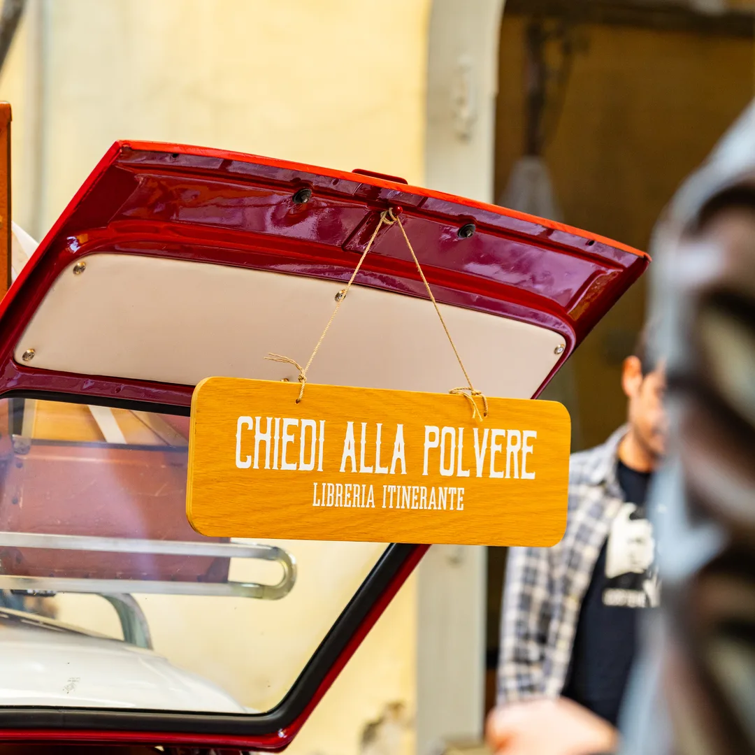 Il retro della Fiat rossa aperto, con l'insegna della libreria itinerante