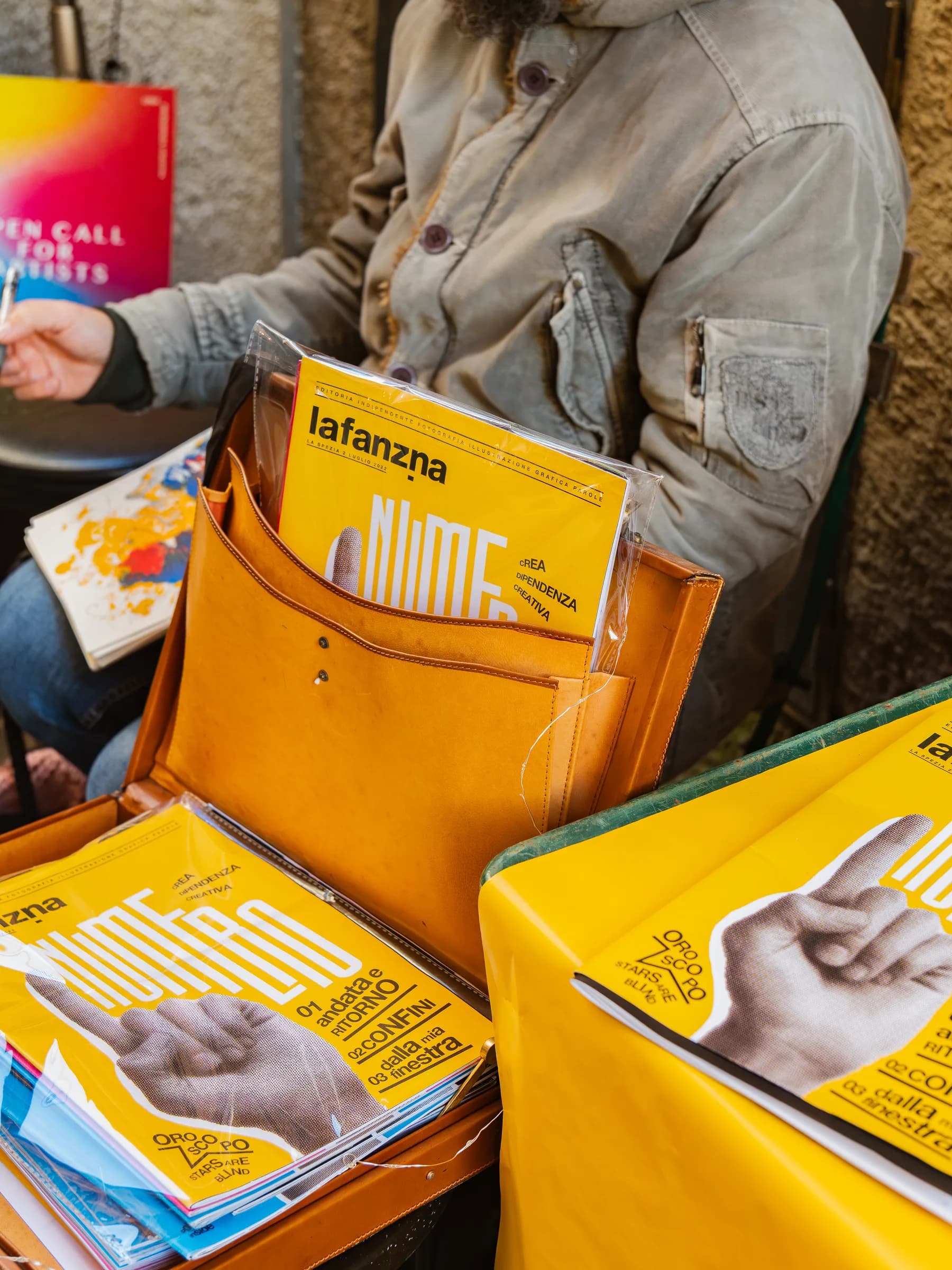 Fanzine e riviste indipendenti esposte su un banco giallo al festival Propaganda
