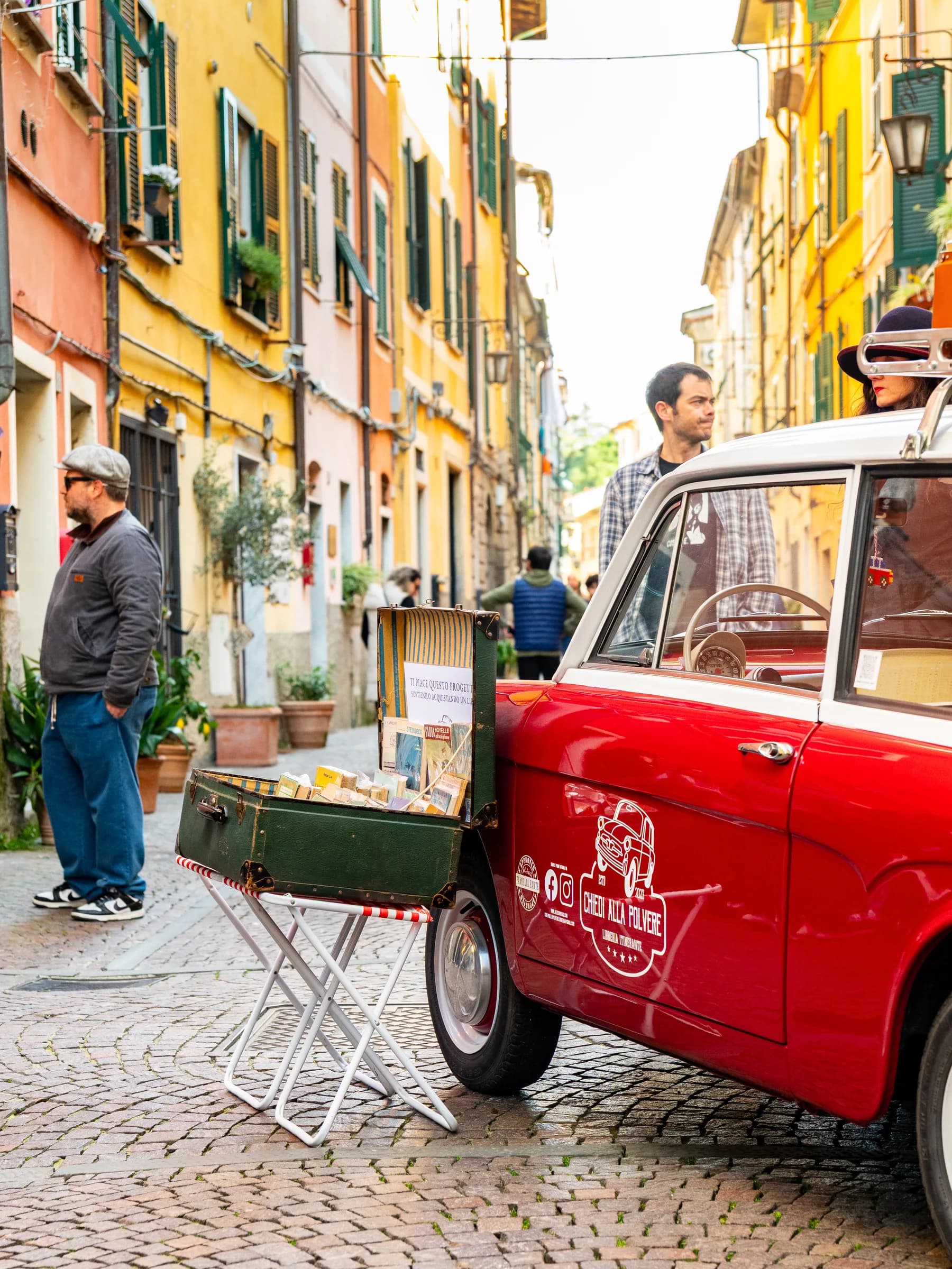 Libreria itinerante ricavata da una Fiat 500 rossa, parcheggiata in un vicolo durante il festival Propaganda