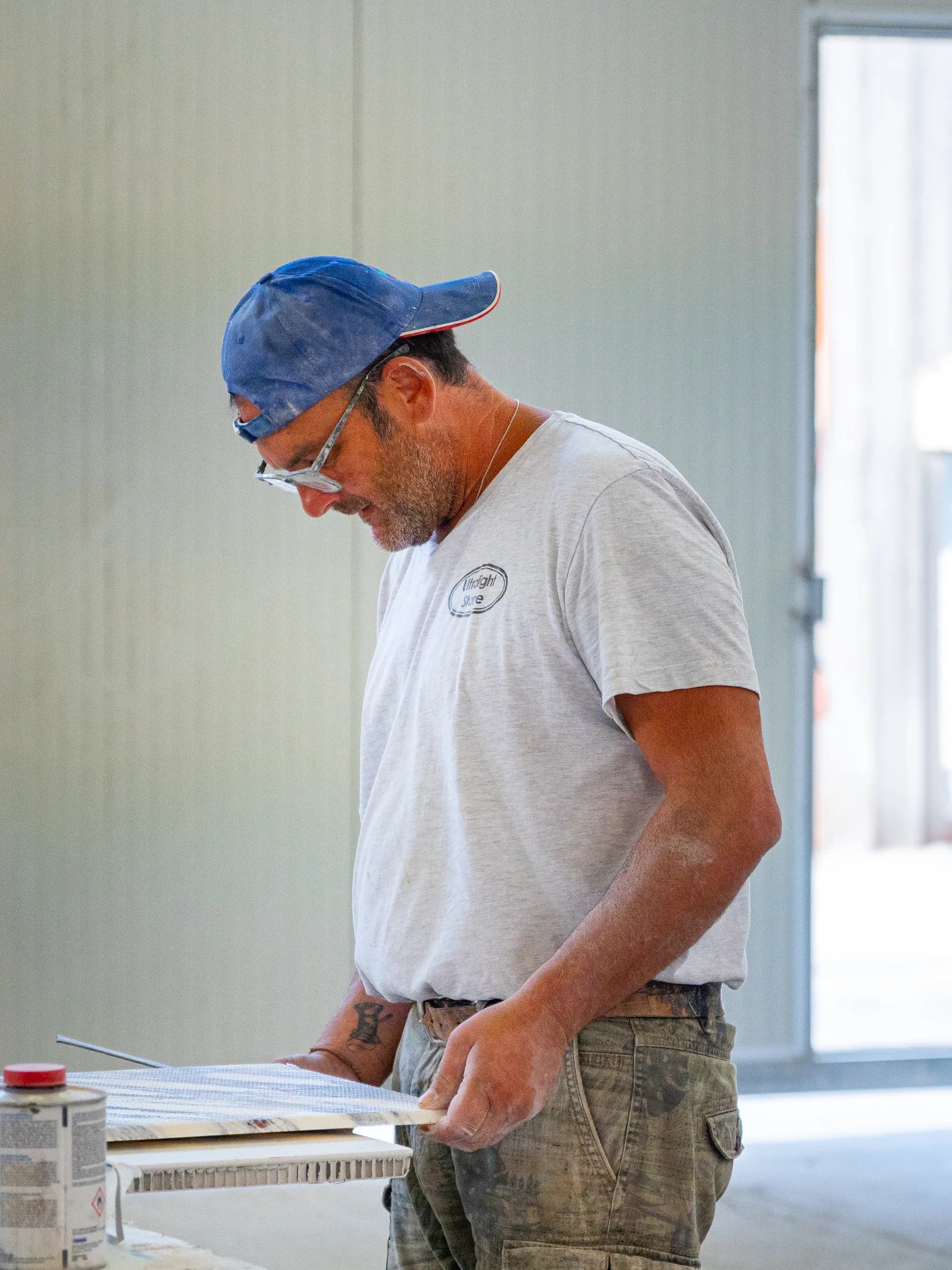 Artigiano al lavoro nel laboratorio Techno Stone, in controluce davanti alla porta aperta