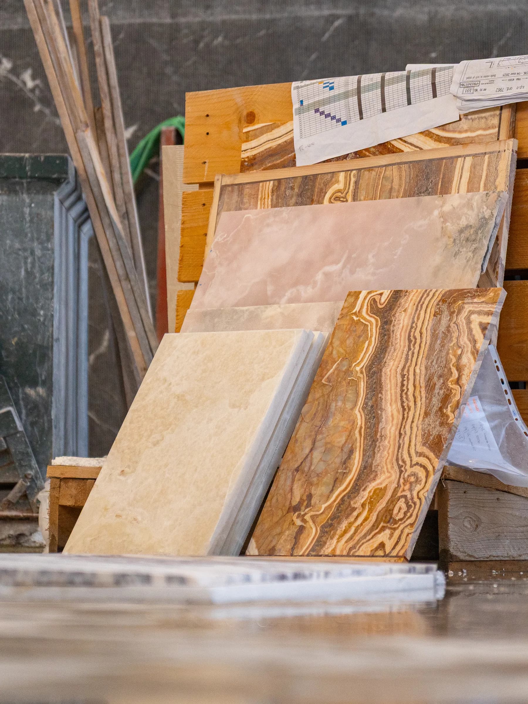 Lastre di onice e travertino appoggiate ai cavalletti di legno nel laboratorio Techno Stone
