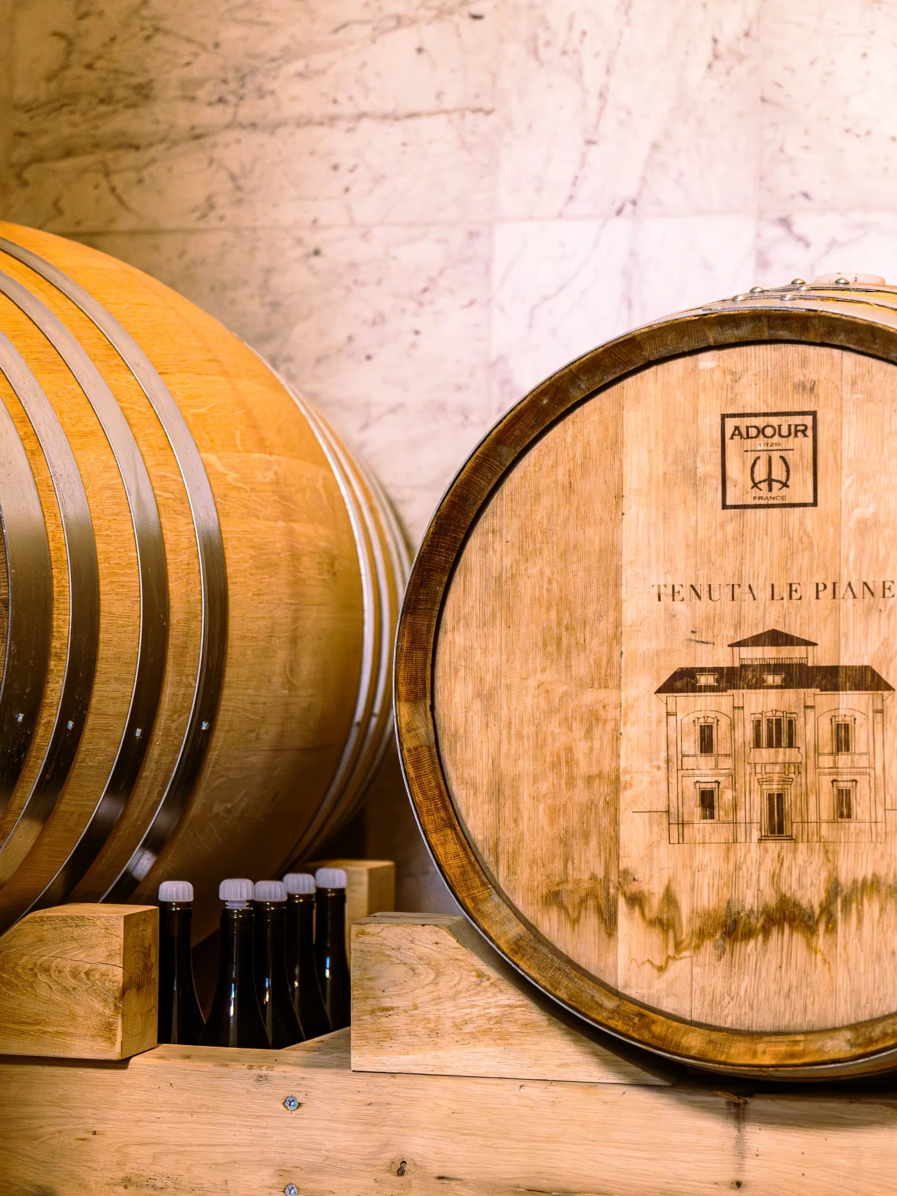 Botti di rovere marchiate a fuoco con lo stemma di Tenuta Le Piane nella cantina