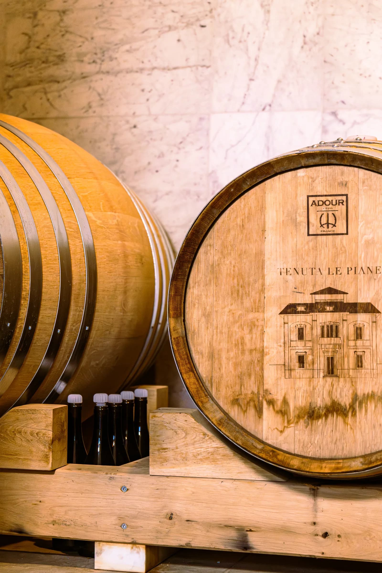 Botti di rovere marchiate a fuoco con lo stemma di Tenuta Le Piane nella cantina