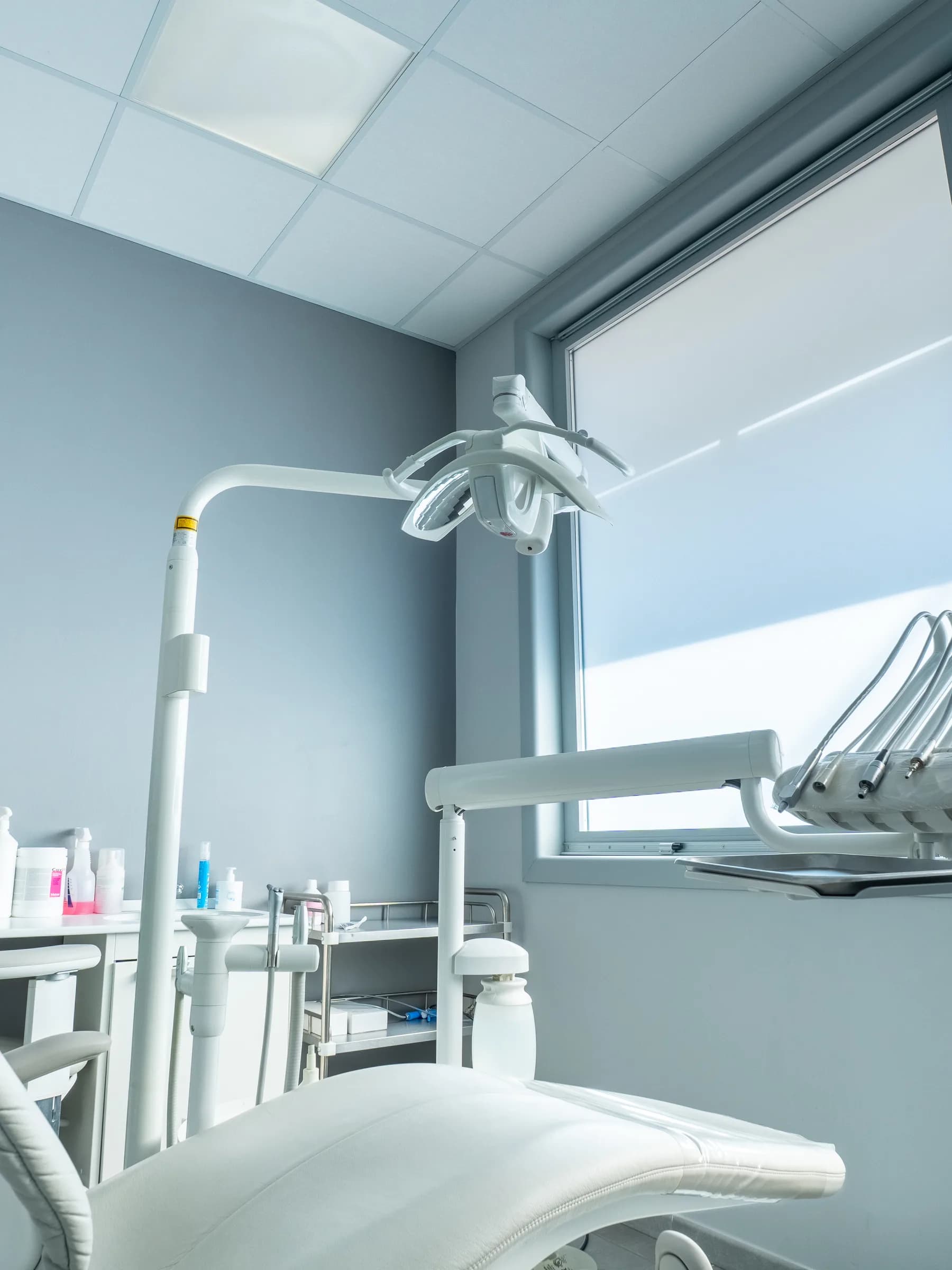 Riunito dentistico bianco nella sala di White, illuminato dalla luce naturale della finestra