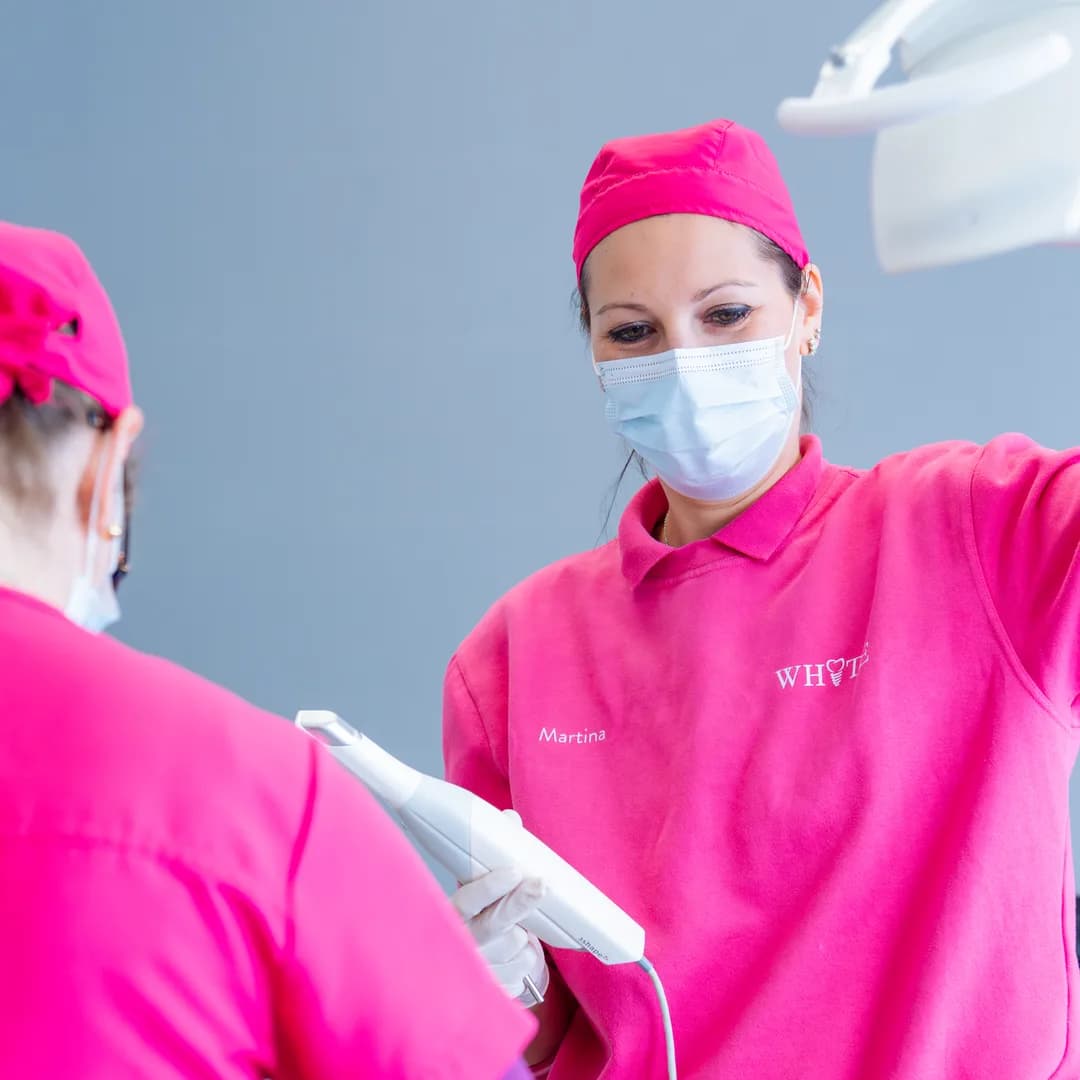Due operatrici regolano la lampada scialitica sopra il riunito