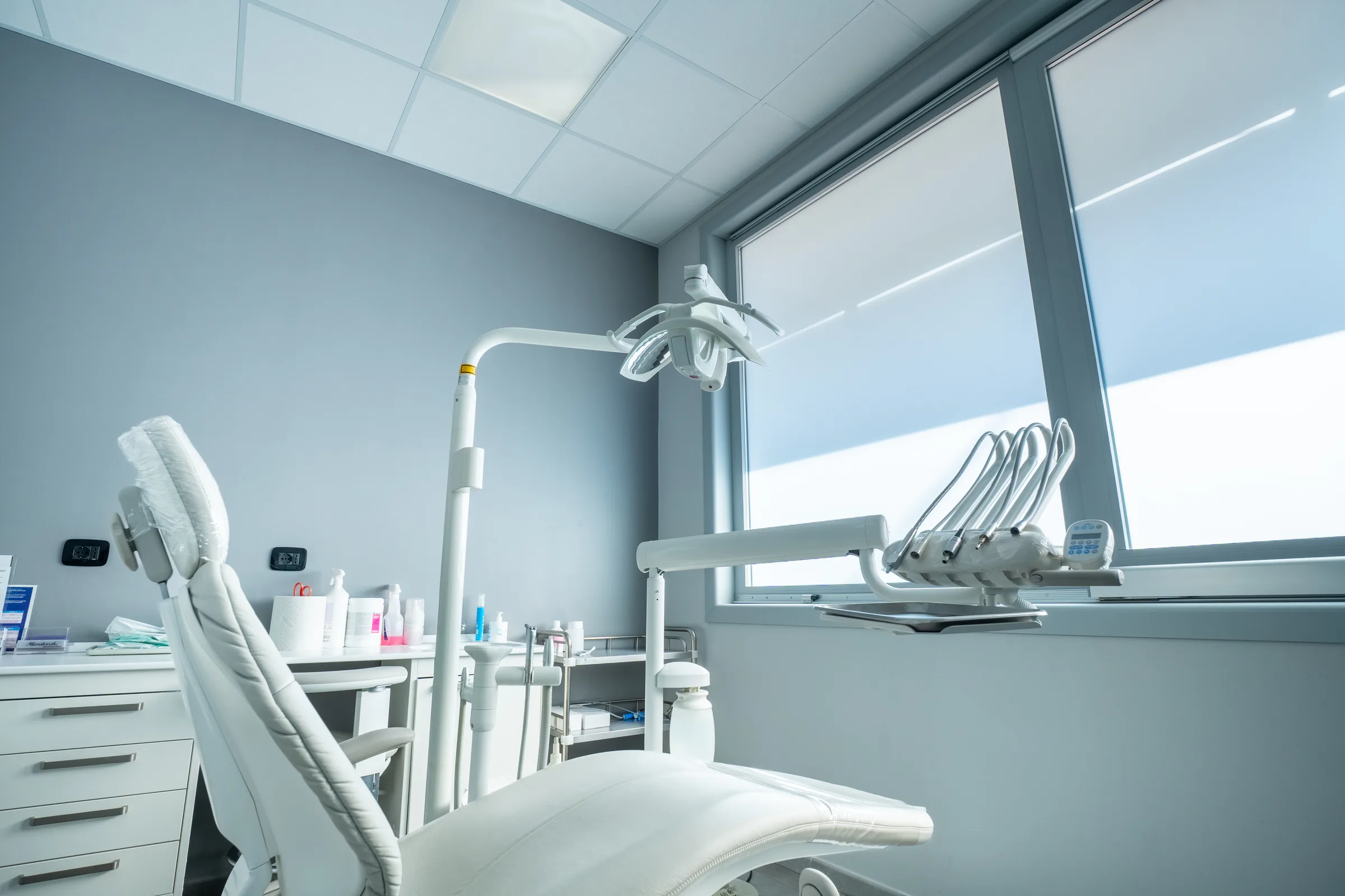 Riunito dentistico bianco nella sala di White, illuminato dalla luce naturale della finestra