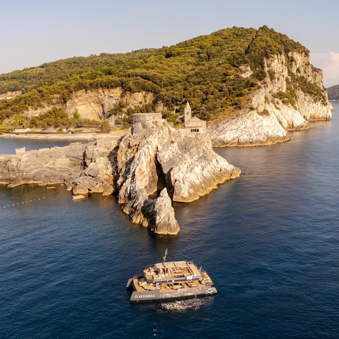 L'isola vista dal drone, col catamarano Alegria all'ancora nell'acqua sotto la scogliera