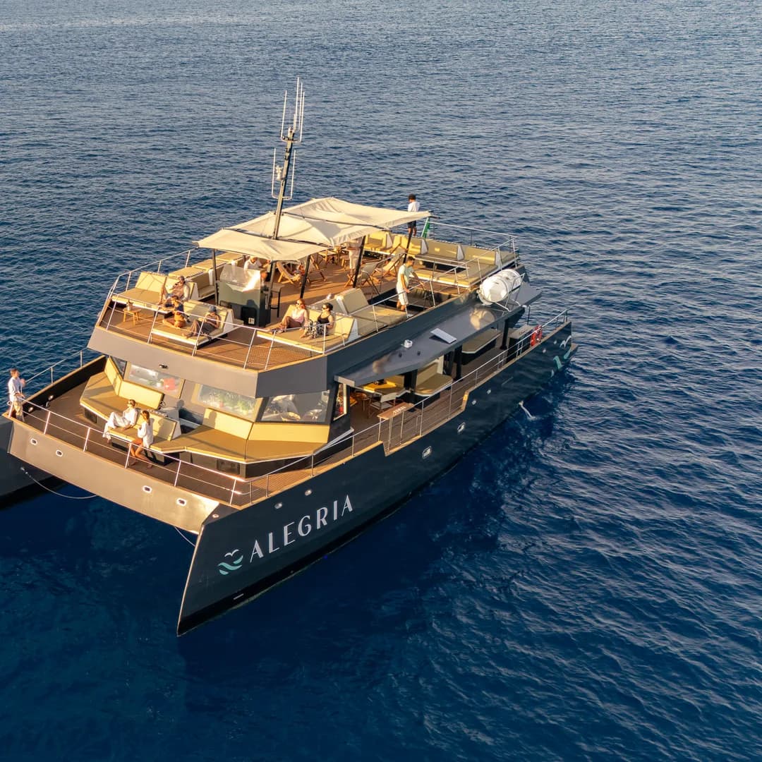Il catamarano Alegria ripreso dal drone di tre quarti, col nome leggibile sullo scafo