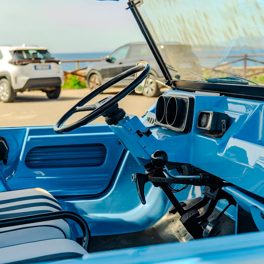 Interno di una spiaggina blu parcheggiata davanti al mare