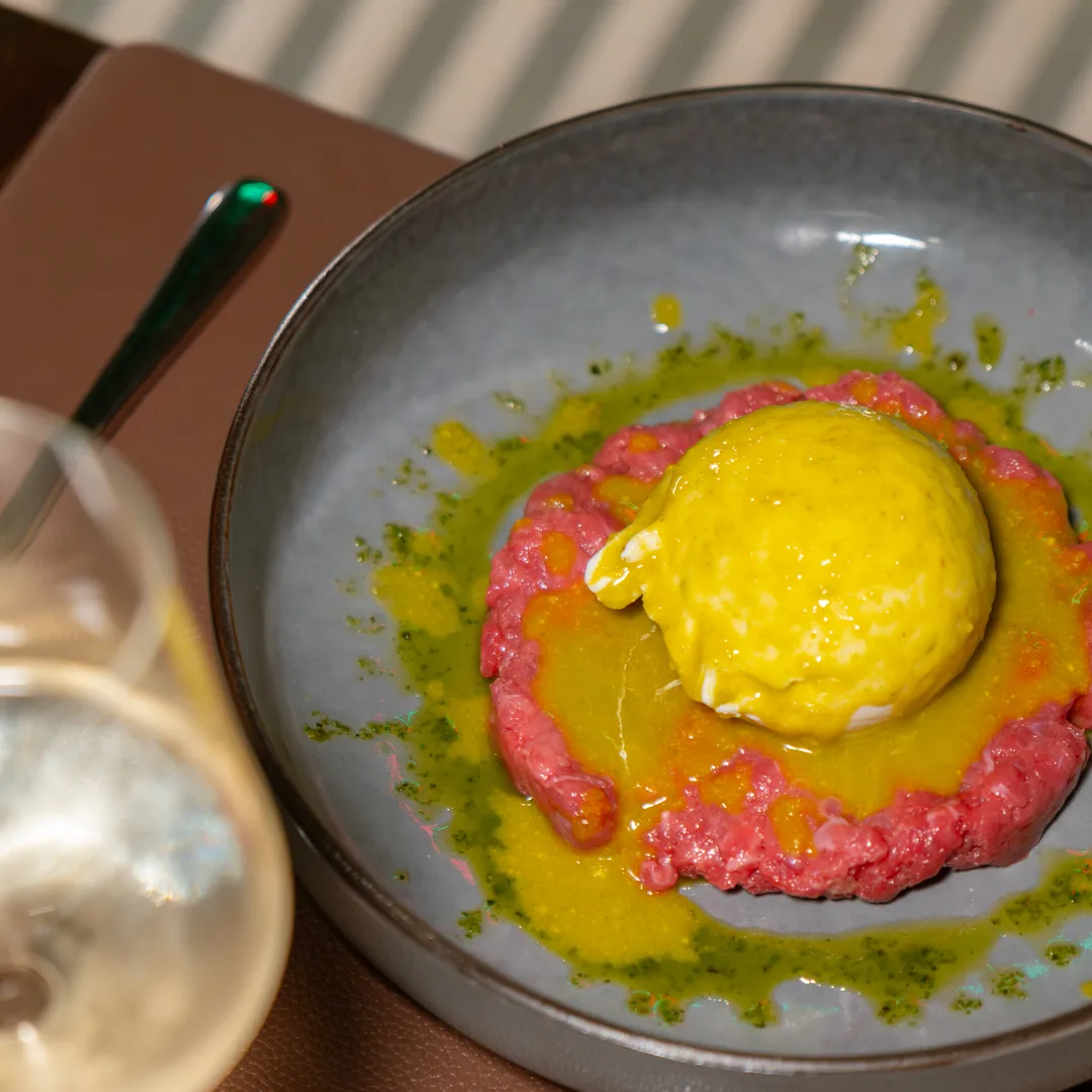 Tartare di manzo col tuorlo al centro, servita nel piatto scuro