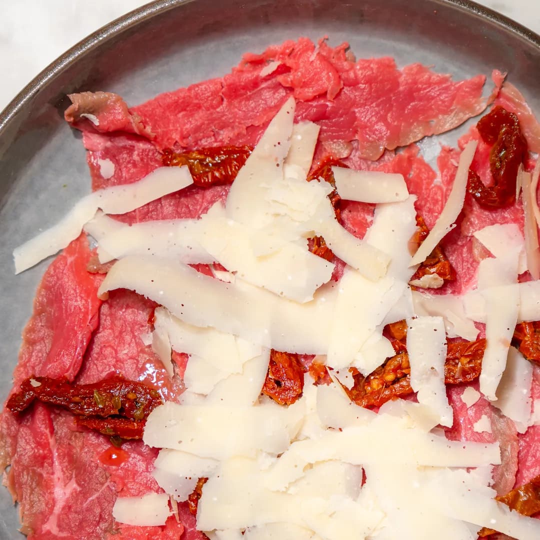 Carpaccio di manzo con scaglie di grana e pomodori secchi